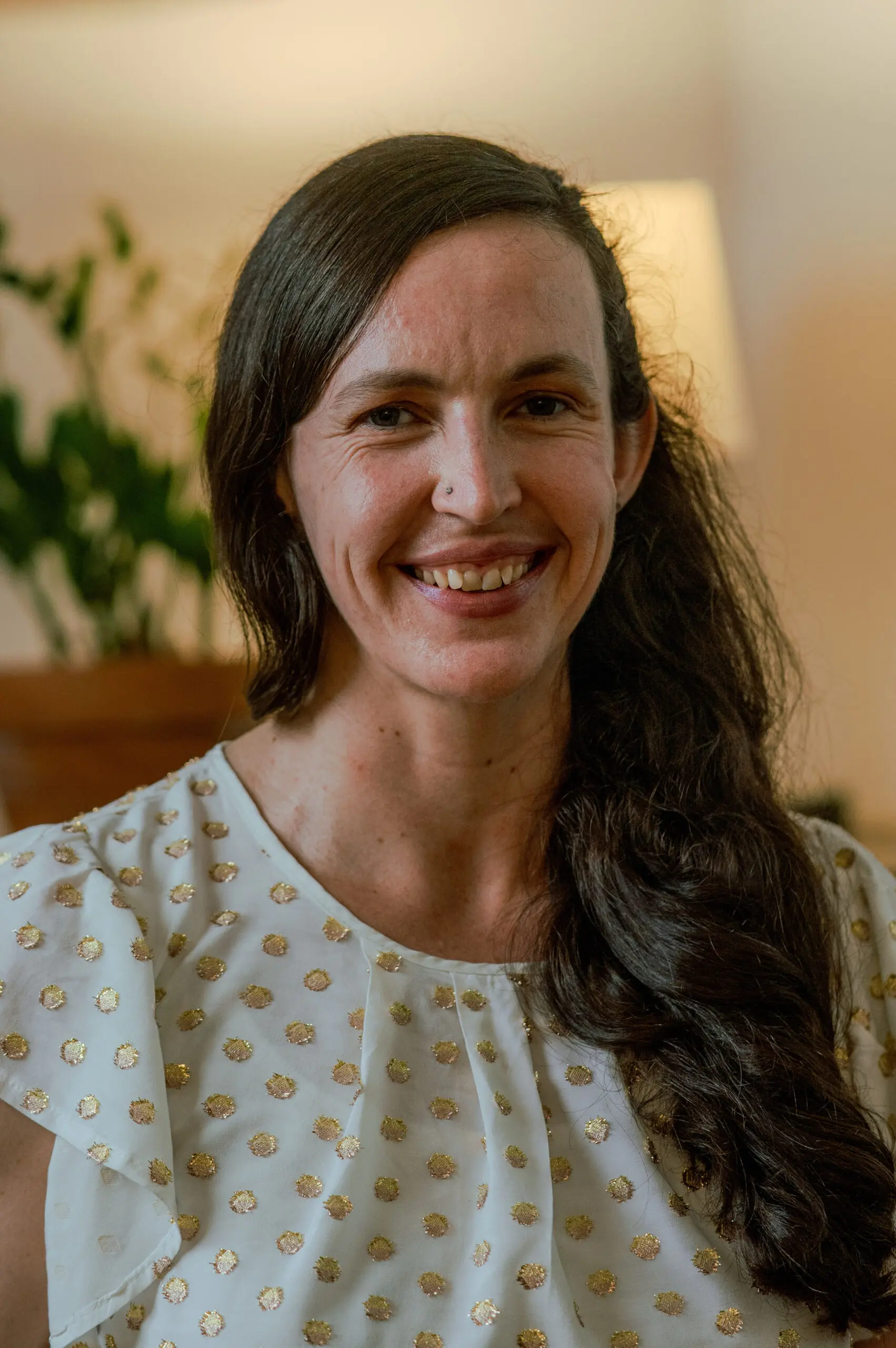 Mindfulness guide Meg Stein seated smiling at the camera .