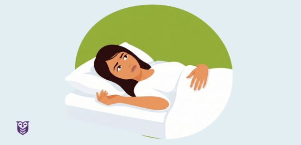 Woman lying in bed on white sheets, unable to sleep.