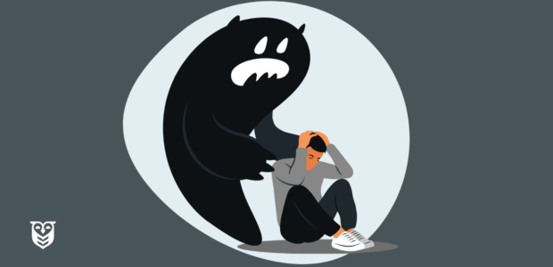 A young man is overwhelmed by anxiety and sits on the floor. A large monster, representing anxiety, is behind him.